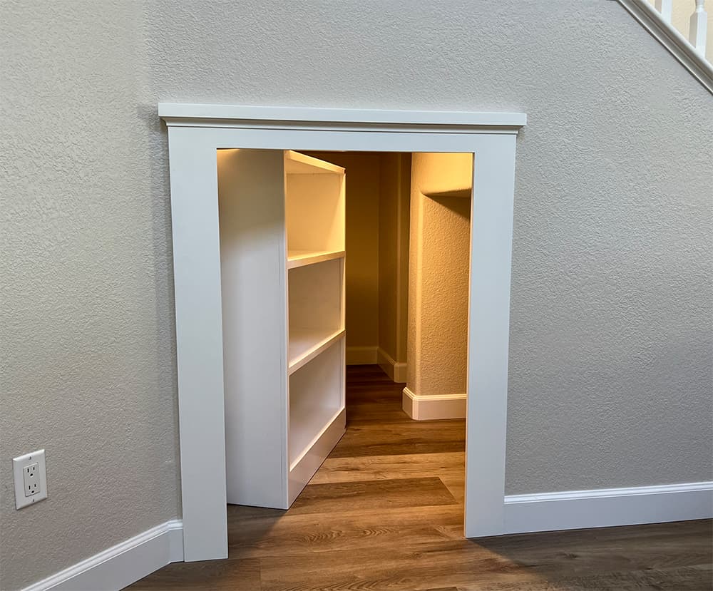 Custom Built-in Bookcase Doubles as a Door to a Secret Room in Poway Home
